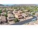 An aerial view of single-Gathering homes in a desert community, featuring a paved street and desert landscaping at 7252 E Nance St, Mesa, AZ 85207