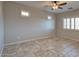 Room with neutral-toned walls, tile flooring, ceiling fan and windows at 7252 E Nance St, Mesa, AZ 85207