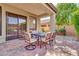 Covered patio has sliding glass doors and an outdoor dining set for alfresco dining and entertaining at 7252 E Nance St, Mesa, AZ 85207