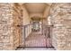 A covered front porch with brick columns and tile floor is accessible through a gated stone archway at 7252 E Nance St, Mesa, AZ 85207