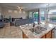 Kitchen view from island with granite countertops, stainless steel sink, and open living area at 7252 E Nance St, Mesa, AZ 85207