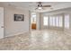 Light-filled main bedroom featuring tiled floors, ceiling fan, and an ensuite bathroom at 7252 E Nance St, Mesa, AZ 85207