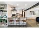 Modern kitchen with stainless steel appliances, light cabinets, breakfast bar, and stylish bar stools at 7326 E Portland St, Scottsdale, AZ 85257