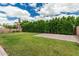 This yard offers a large lawn, a defined gravel area, and mature trees and bushes for privacy at 7528 E Peralta Ave, Mesa, AZ 85212