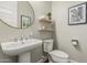 Stylish half bathroom with round mirror, modern fixtures, and classic decor at 7528 E Peralta Ave, Mesa, AZ 85212