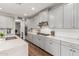 Well-equipped kitchen featuring gray cabinets, stainless steel appliances, quartz countertops, and stylish fixtures at 7528 E Peralta Ave, Mesa, AZ 85212