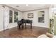 Elegant living room featuring a grand piano and natural light from many windows at 7528 E Peralta Ave, Mesa, AZ 85212