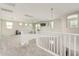 Spacious carpeted loft area with white banister, multiple windows, and ample natural light, perfect for recreation at 7528 E Peralta Ave, Mesa, AZ 85212
