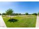 A well-maintained park features walking paths, green lawns, picnic tables and mature trees at 7528 E Peralta Ave, Mesa, AZ 85212