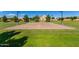 A sand volleyball court is surrounded by lush grass, available in the community park at 7528 E Peralta Ave, Mesa, AZ 85212