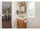 Cozy bathroom features a wood vanity, mirrored medicine cabinet, and a window for natural light at 8330 E Pueblo Ave, Mesa, AZ 85208