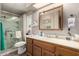 Well-lit bathroom with a wooden vanity, mirrored cabinet, shower stall with seating, and modern fixtures at 8330 E Pueblo Ave, Mesa, AZ 85208