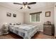 Relaxing bedroom with a ceiling fan, laminate floors, window, and a cozy queen-size bed with decorative quilt at 8330 E Pueblo Ave, Mesa, AZ 85208