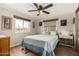 Cozy bedroom featuring a large window, ceiling fan, and comfortable queen bed with a decorative blue comforter at 8330 E Pueblo Ave, Mesa, AZ 85208
