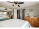 Spacious bedroom with a mirrored closet, ceiling fan, laminate floor, and a queen-size bed with blue and white bedding at 8330 E Pueblo Ave, Mesa, AZ 85208
