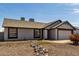 Single-level home featuring an attached two-car garage and low-maintenance desert landscaping at 8703 W Golden Ln, Peoria, AZ 85345