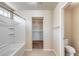 Well-lit bathroom featuring a tub/shower combo, toilet, and walk-in closet at 9 N 87Th N Ln, Tolleson, AZ 85353
