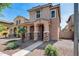 Two-story home with covered entryway, landscaped front yard with desert rock and desert vegetation at 9 N 87Th N Ln, Tolleson, AZ 85353