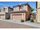 Two-story home featuring an attached garage, a desert-landscaped yard, and a brick-paved street at 9 N 87Th N Ln, Tolleson, AZ 85353