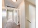 Neutral hallway with carpet, doors, and wall mounted handrail at 9 N 87Th N Ln, Tolleson, AZ 85353