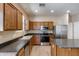 Well-lit kitchen featuring wooden cabinets, stainless steel appliances, and a functional island at 9 N 87Th N Ln, Tolleson, AZ 85353
