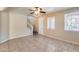 Living room featuring tile flooring, staircase, ceiling fan, and bright, natural light at 9 N 87Th N Ln, Tolleson, AZ 85353