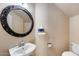 Compact powder room with a decorative mirror and convenient placement near the main living areas at 9 N 87Th N Ln, Tolleson, AZ 85353