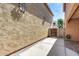 Narrow side yard with concrete and brick paving, featuring secure gated access at 9 N 87Th N Ln, Tolleson, AZ 85353