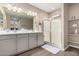 Bathroom with double sinks, shower, and closet shelving, features wood look tile flooring at 1297 W Chillingham W Rd, San Tan Valley, AZ 85143