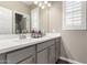 Bathroom vanity featuring dual sinks, gray cabinetry, chrome hardware, and plantation shutters at 1297 W Chillingham W Rd, San Tan Valley, AZ 85143