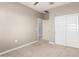 The carpeted bedroom features neutral walls, a ceiling fan, and a closet with mirrored sliding doors at 1297 W Chillingham W Rd, San Tan Valley, AZ 85143