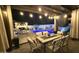 Cozy outdoor dining area illuminated by string lights, perfect for evening gatherings by the pool at 1297 W Chillingham W Rd, San Tan Valley, AZ 85143