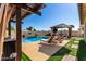 Backyard oasis featuring a refreshing pool, lounge chairs, pergola with curtains, and outdoor seating areas at 1297 W Chillingham W Rd, San Tan Valley, AZ 85143