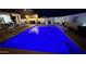 Sparkling backyard pool, lit up with blue lights for a vibrant nighttime ambiance, complete with lounge area and outdoor bar at 1297 W Chillingham W Rd, San Tan Valley, AZ 85143