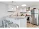 Bright kitchen with white cabinets, stainless steel appliances, granite countertops and barstool seating at 13013 N 18Th St, Phoenix, AZ 85022