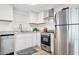 Renovated kitchen with stainless steel appliances, white cabinets, stone countertops and luxury vinyl flooring at 13013 N 18Th St, Phoenix, AZ 85022