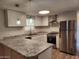 Bright kitchen features stainless steel appliances, granite countertops, and modern pendant lighting at 13013 N 18Th St, Phoenix, AZ 85022