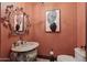 Elegant powder room featuring a decorative mirror, marble vanity, and artistic wall decor at 1330 N 40Th St # 1, Mesa, AZ 85205