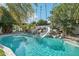 Sparkling pool featuring a rock waterfall and slide, surrounded by mature palm trees and lush landscaping at 1330 N 40Th St # 1, Mesa, AZ 85205
