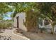 Exterior view of the pool house covered in vines with a wooden door and adjacent glass enclosed area at 1330 N 40Th St # 1, Mesa, AZ 85205