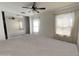Spacious main bedroom with mirrored closet and large windows and a ceiling fan at 1354 S 228Th Dr, Buckeye, AZ 85326