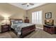 Bedroom with a wooden bed frame, carpeted floors, and white plantation shutters at 14708 E Canyoncrest Ct, Fountain Hills, AZ 85268