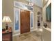 Inviting foyer with stone floors, decorative lighting, and custom wood front door with sidelights at 14708 E Canyoncrest Ct, Fountain Hills, AZ 85268