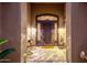 Welcoming front entrance with an ornate metal door, stylish sconces, and charming seating area at 14708 E Canyoncrest Ct, Fountain Hills, AZ 85268