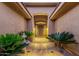 Inviting front entrance featuring a decorative metal door, stone walkway, lush plants, and charming water fountain at 14708 E Canyoncrest Ct, Fountain Hills, AZ 85268