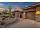 Home exterior with desert landscaping and a two-car garage with lights at 14708 E Canyoncrest Ct, Fountain Hills, AZ 85268