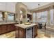 Kitchen island with seating, wine cooler, and granite countertops near a bright breakfast nook at 14708 E Canyoncrest Ct, Fountain Hills, AZ 85268