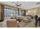Bright living room with large windows, a comfortable sectional sofa, and dining area with stylish chandelier at 14708 E Canyoncrest Ct, Fountain Hills, AZ 85268