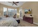 Spacious main bedroom featuring large windows, carpet, ceiling fan, door to patio, and a wall-mounted TV at 14708 E Canyoncrest Ct, Fountain Hills, AZ 85268