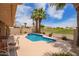 Sparkling pool with views of the golf course, surrounded by lush landscaping and towering palm trees at 15827 S 12Th Pl, Phoenix, AZ 85048